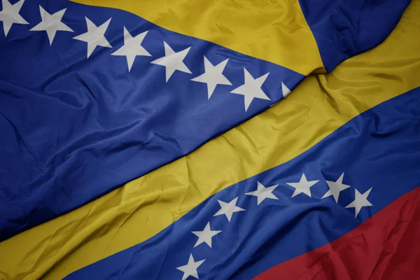 ベネズエラのカラフルな旗とボスニア・ヘルツェゴビナの国旗を振る — ストック写真