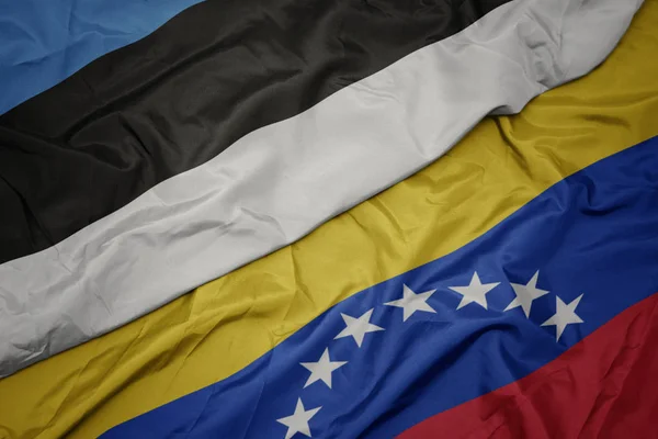 Хвилястий барвистий прапор Венесуели та національний прапор Естонії . — стокове фото