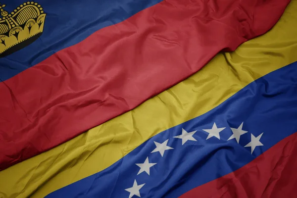 ベネズエラのカラフルな旗とリヒテンシュタインの国旗を振る. — ストック写真