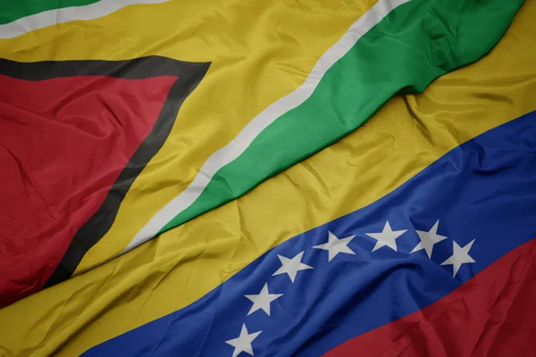 Falujące kolorowe flagi Wenezueli i flagi narodowej Gujany. — Zdjęcie stockowe