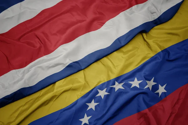ベネズエラのカラフルな旗とコスタリカの国旗を振る. — ストック写真