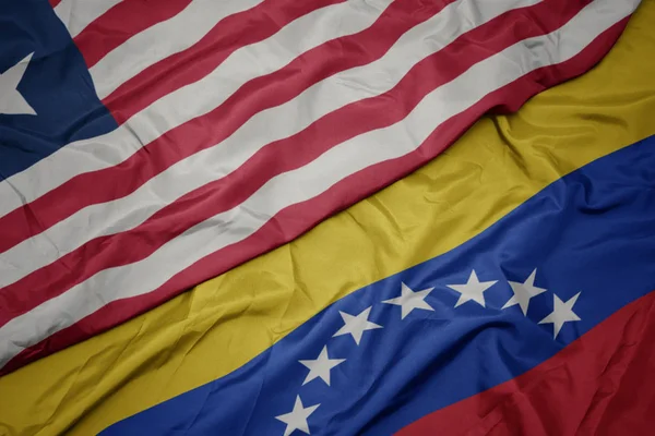 Waving colorful flag of venezuela and national flag of liberia. — Stock Photo, Image