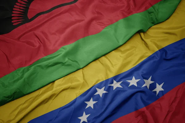 Acenando bandeira colorida da Venezuela e bandeira nacional do Malawi . — Fotografia de Stock