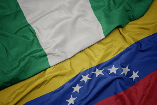 Viftande färgglada flagga Venezuela och nationella flaggan i Nigeria. — Stockfoto