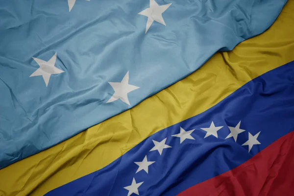 挥舞着五颜六色的委内瑞拉国旗和密克罗尼西亚联邦国旗 . — 图库照片