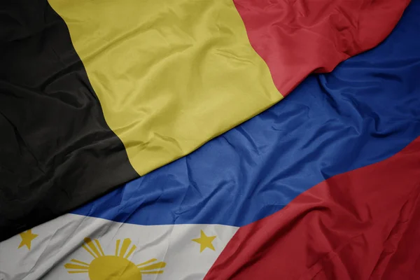 Sventolando bandiera colorata delle filippine e bandiera nazionale del belgio . — Foto Stock