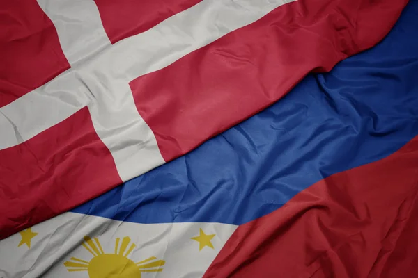 Vinka färgglada flagga av Filippinerna och nationella flaggan i Danmark. — Stockfoto