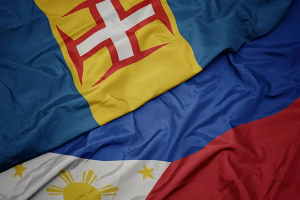 Filipinler renkli bayrak ve madeira ulusal bayrak sallayarak. — Stok fotoğraf