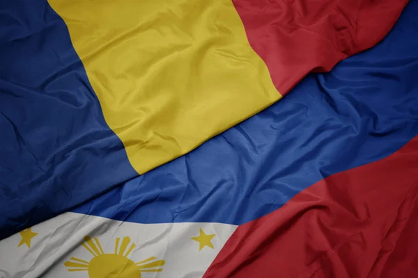 Ondeando colorida bandera de Filipinas y bandera nacional de romania . —  Fotos de Stock