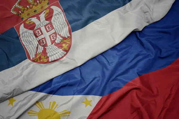 Розмахуючи барвистий прапор Філіппін і Національний прапор Сербії. — стокове фото