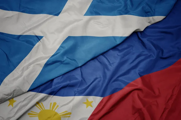 Ondeando colorida bandera de Filipinas y bandera nacional de Escocia . —  Fotos de Stock