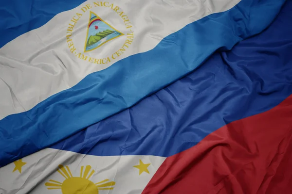 Waving colorful flag of philippines and national flag of nicaragua. — Stock Photo, Image