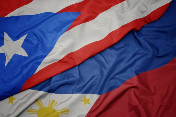 Ondeando colorida bandera de Filipinas y bandera nacional de Puerto Rico . — Foto de Stock