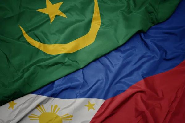 Ondeando colorida bandera de Filipinas y bandera nacional de Mauritania . — Foto de Stock