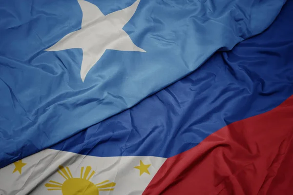 挥舞着五颜六色的菲律宾国旗和索马里国旗. — 图库照片