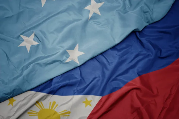 Ondeando colorida bandera de Filipinas y bandera nacional de los Estados Federados de Micronesia  . — Foto de Stock