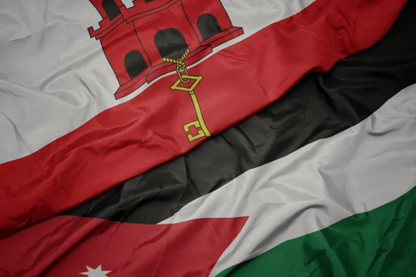 Waving colorful flag of jordan and national flag of gibraltar. — Stock Photo, Image