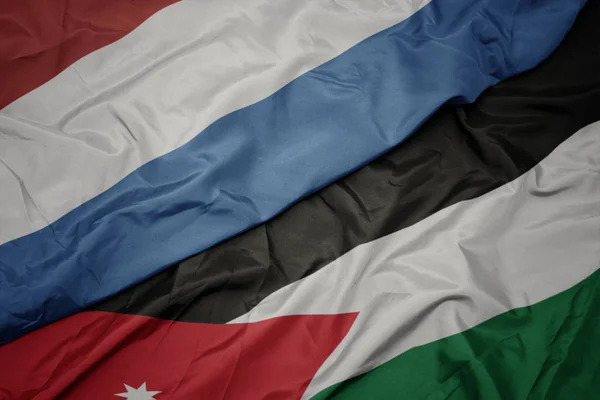 Acenando bandeira colorida da Jordânia e bandeira nacional do Luxemburgo . — Fotografia de Stock