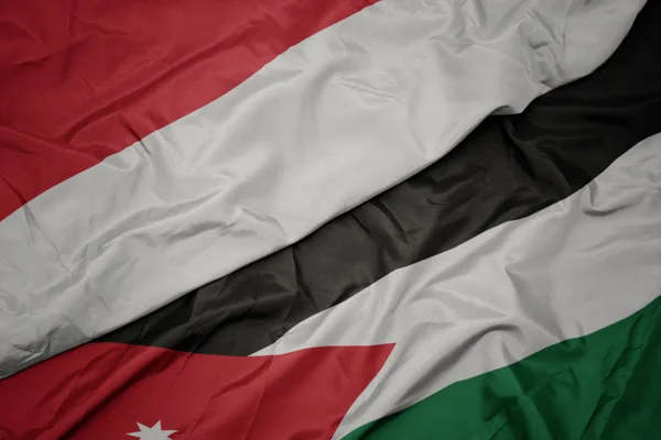 Acenando bandeira colorida da Jordânia e bandeira nacional da indonésia . — Fotografia de Stock