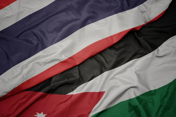 Acenando bandeira colorida da Jordânia e bandeira nacional da Tailândia . — Fotografia de Stock