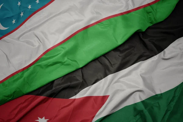 A Jordán zászló színes zászlója és Üzbegisztán nemzeti zászlaja. — Stock Fotó