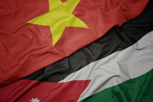 Zwaaiende kleurrijke vlag van Jordanië en de nationale vlag van Vietnam. — Stockfoto