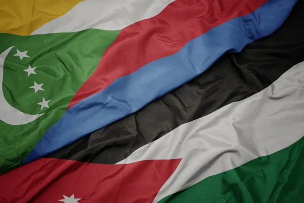 Ondeando colorida bandera de Jordania y bandera nacional de las comoras . — Foto de Stock