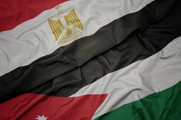 Acenando bandeira colorida da Jordânia e bandeira nacional do Egito — Fotografia de Stock