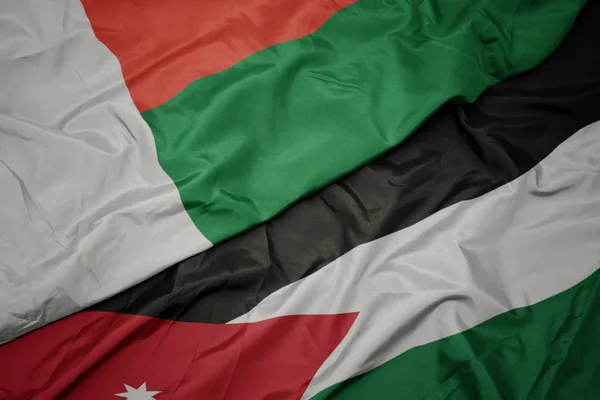 Waving colorful flag of jordan and national flag of madagascar. — Stock Photo, Image