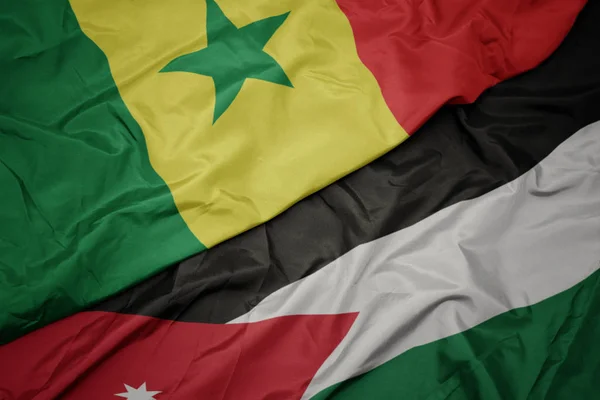 Schwenken bunte jordanische und senegalesische Nationalflagge. — Stockfoto