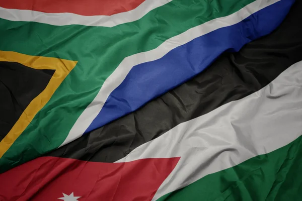 Agitant drapeau coloré de jordanie et drapeau national de l'Afrique du Sud . — Photo