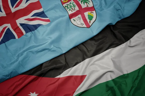 ヨルダンのカラフルな旗とフィジーの国旗を振る . — ストック写真