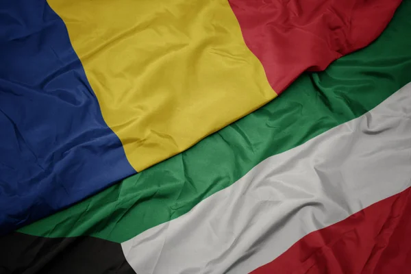 Ondeando colorida bandera de kuwait y bandera nacional de romania . —  Fotos de Stock