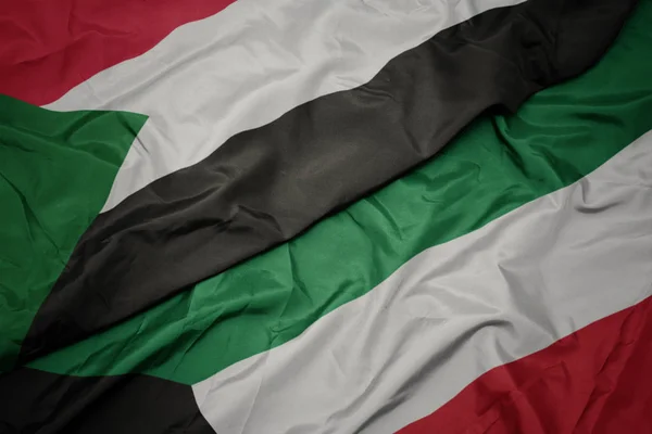 Waving colorful flag of kuwait and national flag of sudan. — Stock Photo, Image