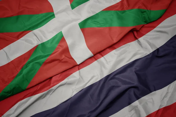 Falujące kolorowe flagi Tajlandii i flagi narodowej kraju Basków. — Zdjęcie stockowe