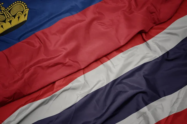 Falujące kolorowe flagi Tajlandii i flagi narodowej Liechtensteinu. — Zdjęcie stockowe
