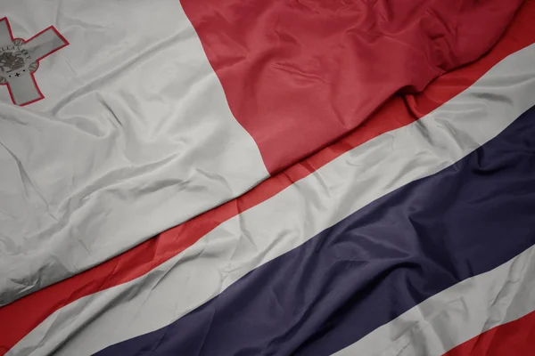 Zwaaiende kleurrijke vlag van Thailand en de nationale vlag van Malta. — Stockfoto