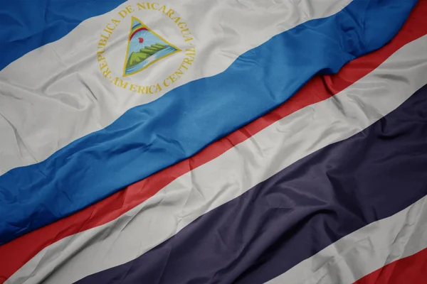 Tayland renkli bayrak ve nikaragua ulusal bayrak sallayarak. — Stok fotoğraf