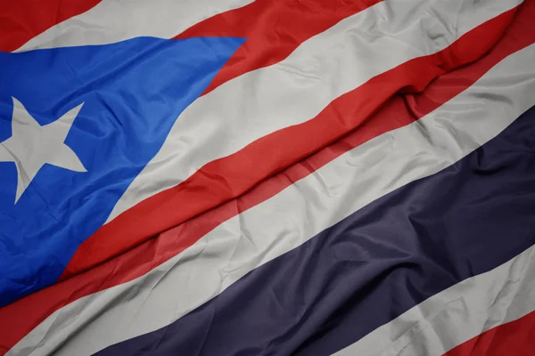 Zwaaiende kleurrijke vlag van Thailand en de nationale vlag van Puerto Rico. — Stockfoto