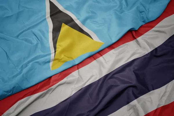 Agitant drapeau coloré de Thaïlande et drapeau national de Sainte-Lucie . — Photo