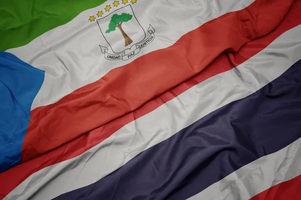 Sventolando bandiera colorata della Thailandia e bandiera nazionale della Guinea equatoriale . — Foto Stock
