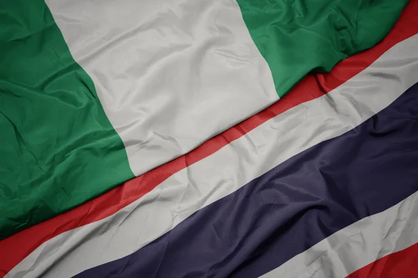 Integetett színes zászló Thaiföld és a nemzeti zászló Nigéria. — Stock Fotó