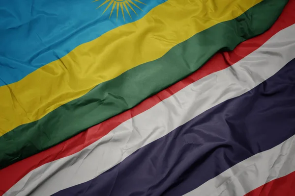 Waving colorful flag of thailand and national flag of rwanda. — Stock Photo, Image