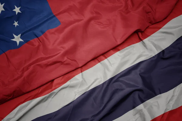 Размахивая красочным флагом Таиланда и национальным флагом Самоа  . — стоковое фото