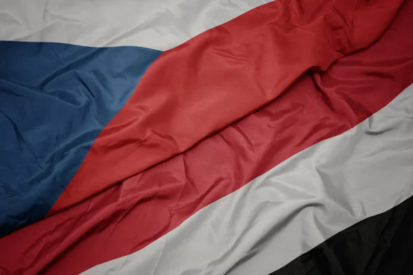 Mávající barevná vlajka Jemenu a národní vlajka České republiky. — Stock fotografie