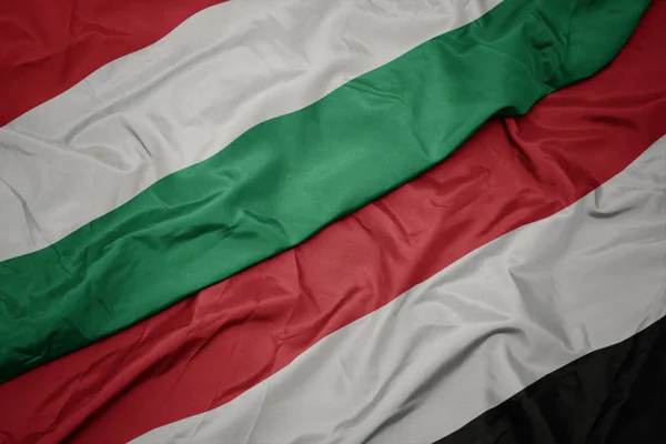 Waving colorful flag of yemen and national flag of hungary. — Stock Photo, Image