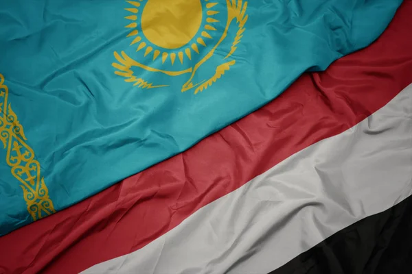 Ondeando colorida bandera de yemen y bandera nacional de kazakhstan . — Foto de Stock