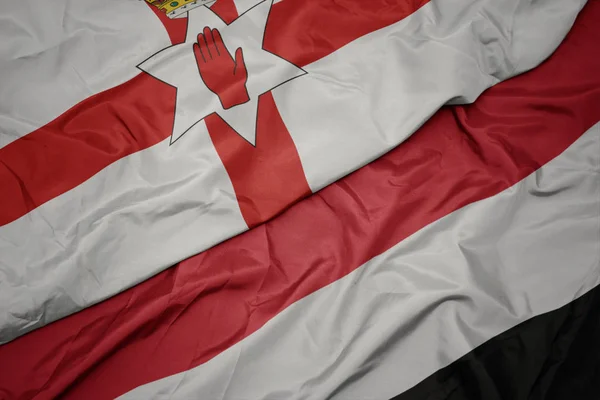 Jemeni színes zászló és Észak-Írország nemzeti zászlaja. — Stock Fotó