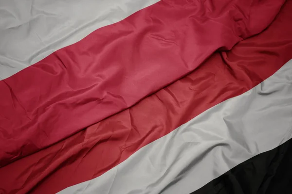 Ondeando bandera colorida de yemen y bandera nacional de poland . — Foto de Stock