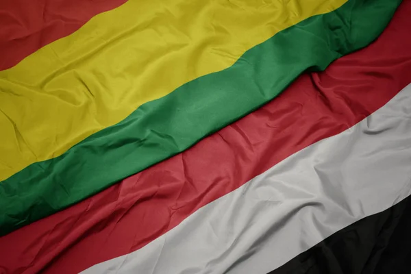 Ondeando colorida bandera de yemen y bandera nacional de bolivia . — Foto de Stock